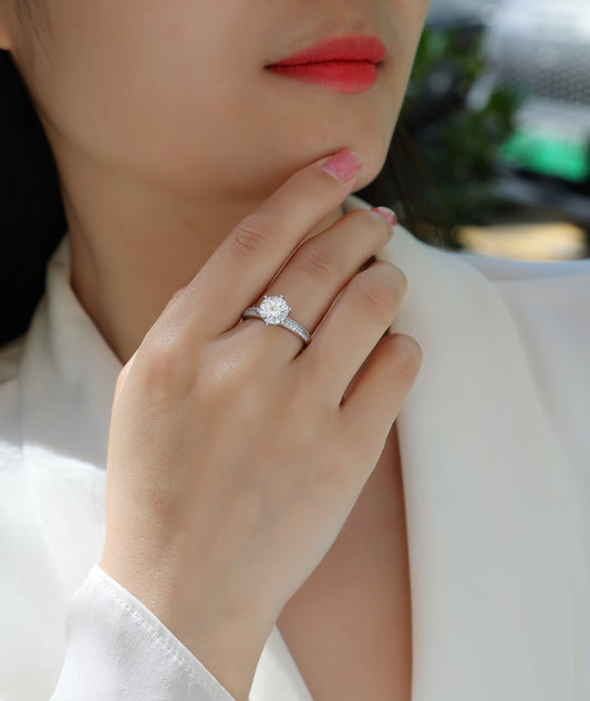 Close-up of a hand wearing a diamond ring with a blurred background