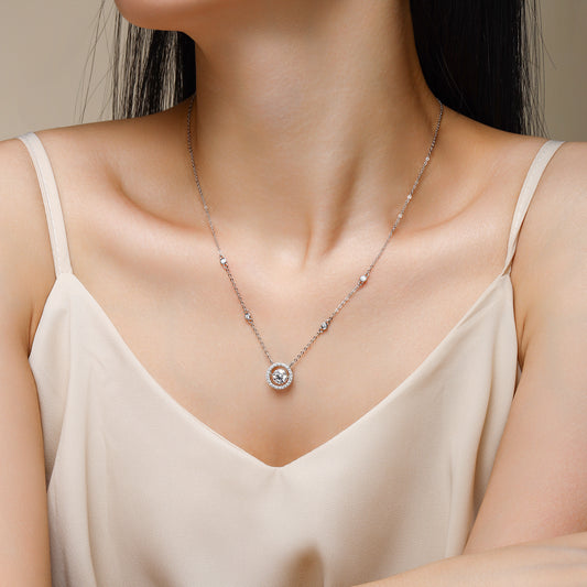Necklace with a round pendant worn by a model in a beige top.